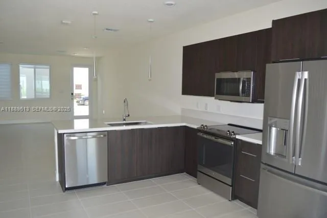 a kitchen with stainless steel appliances granite countertop a refrigerator and a stove top oven