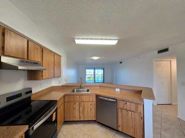 a kitchen with stainless steel appliances granite countertop a refrigerator a stove and a sink