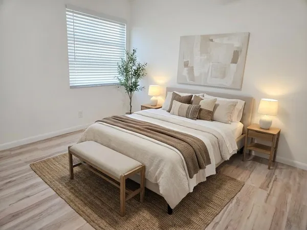 a view of an empty room with wooden floor and a ceiling fan