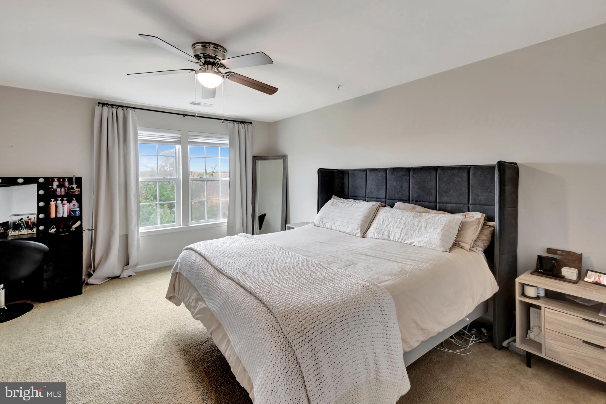 2063 Spring Run Circle Frederick, MD 21702 - Photo 17 of 28 a large bed sitting in a bedroom next to a window with a chandelier