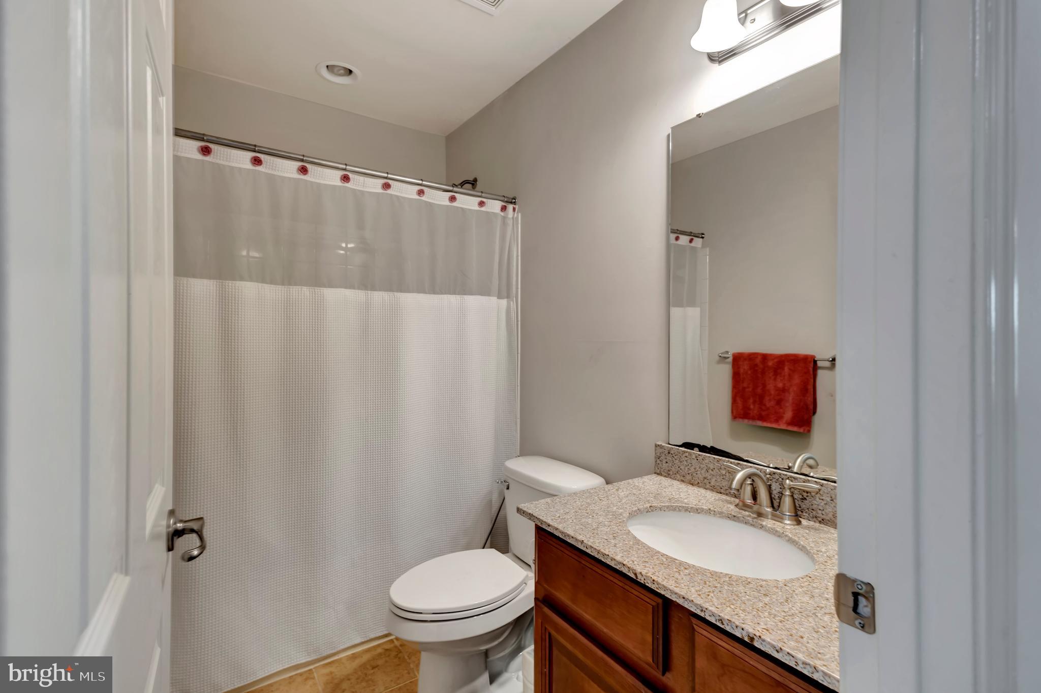 2063 Spring Run Circle Frederick, MD 21702 - Photo 25 of 28 a bathroom with a granite countertop sink toilet and a mirror