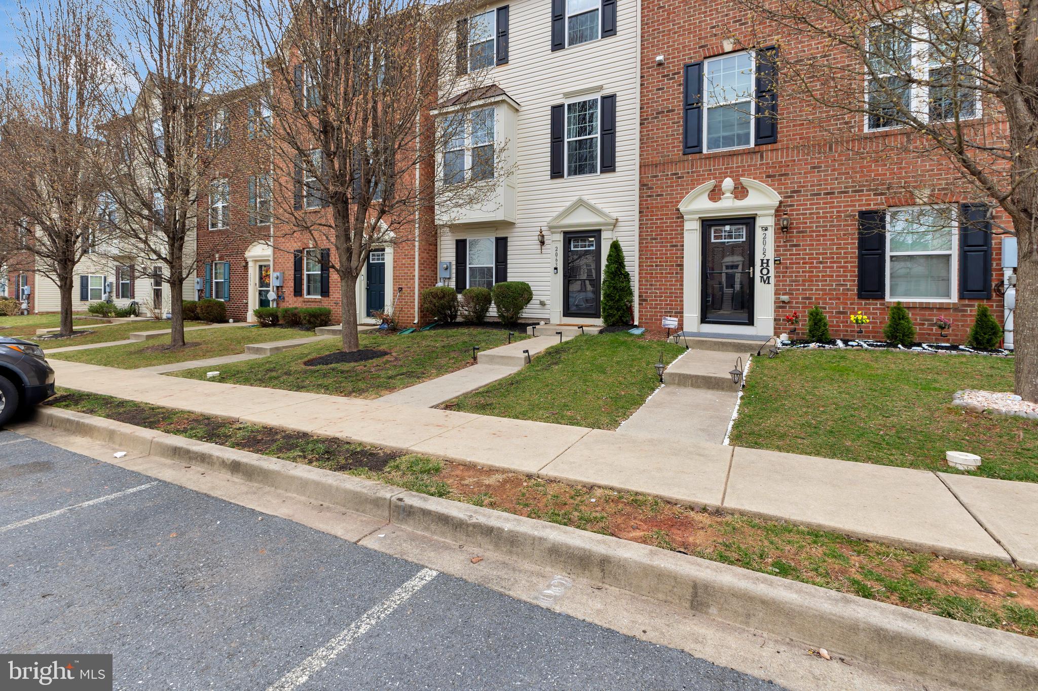 2063 Spring Run Circle Frederick, MD 21702 - Photo 3 of 28 front view of a brick house next to a yard