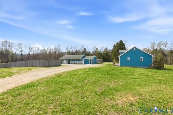 a view of a house with a big yard and large trees