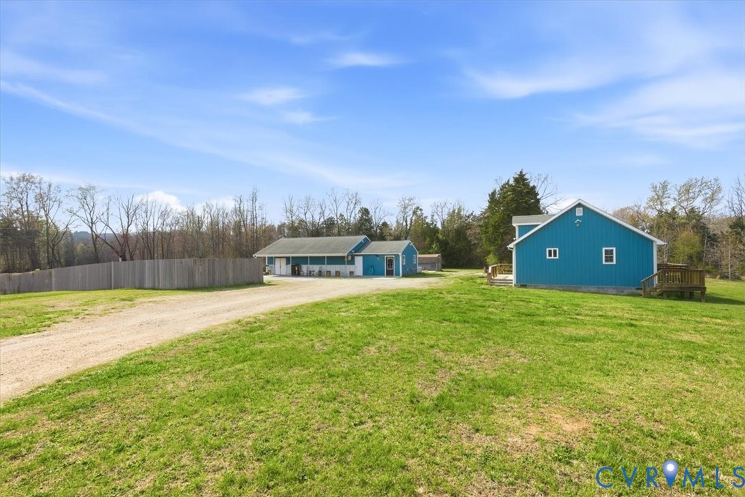 a view of a house with a big yard and large trees