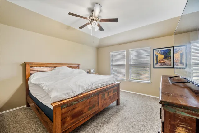 a bed sitting in a spacious bedroom next to a window