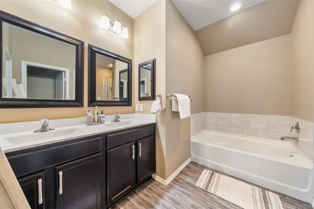 a bathroom with a tub sink and mirror