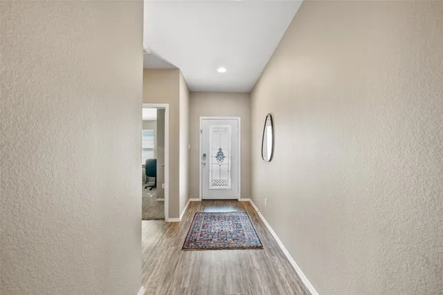 a view of a hallway with wooden floor