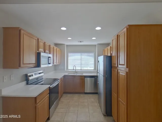 a kitchen with stainless steel appliances granite countertop a refrigerator and a sink