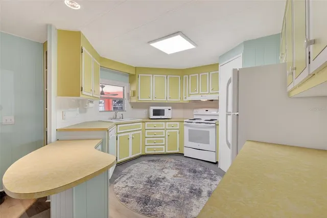 a kitchen that has a sink cabinets counter space and appliances