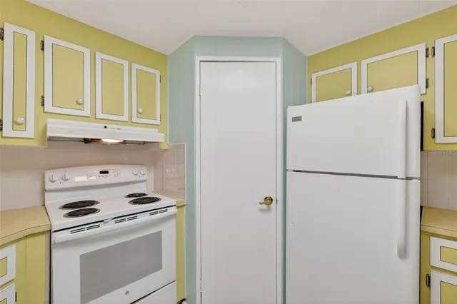a white refrigerator freezer and a stove sitting inside of a kitchen
