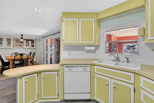a utility room with stainless steel appliances granite countertop a sink and a cabinets
