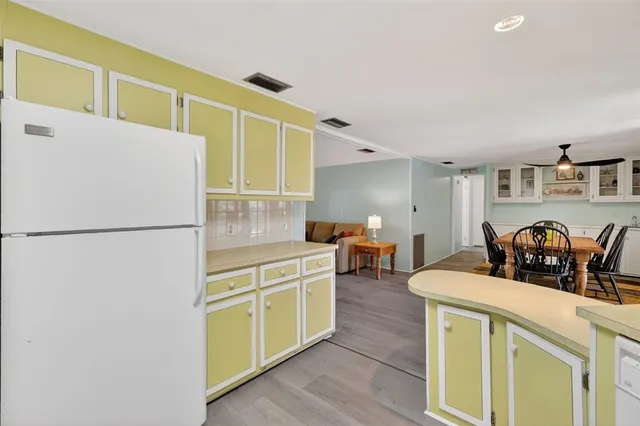 a kitchen with stainless steel appliances a refrigerator sink and white cabinets