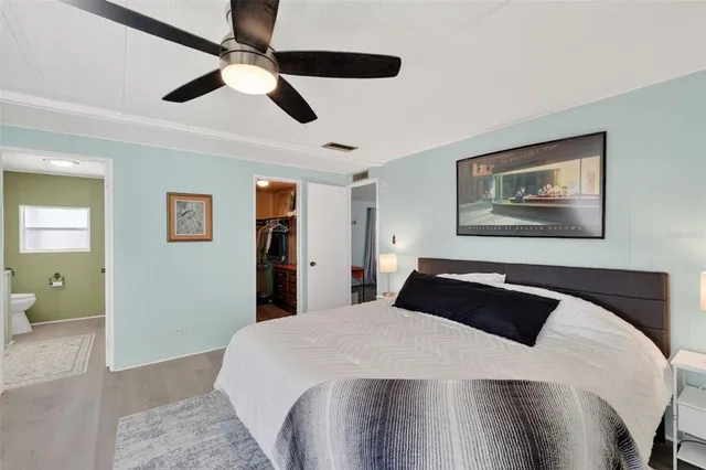 a bedroom with a large bed and a chandelier