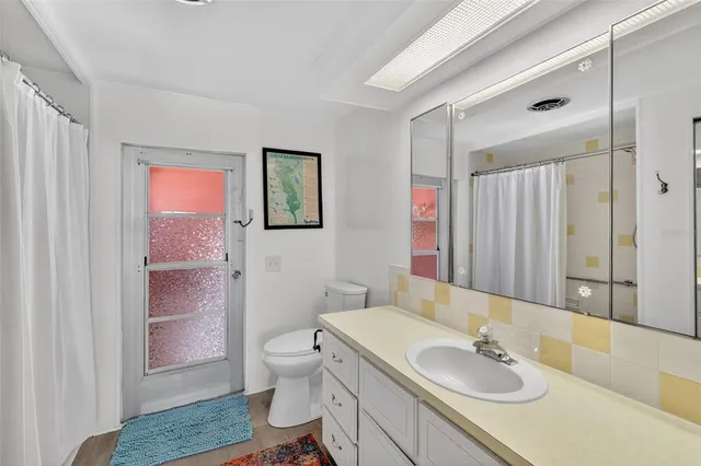 a bathroom with a sink toilet double vanity and shower