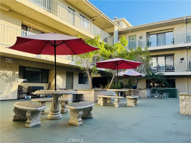 a view of a patio with table and chairs under an umbrella