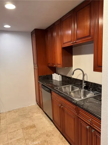 a kitchen with granite countertop stainless steel appliances a sink and cabinets