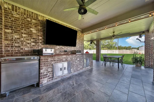 a living room with stainless steel appliances furniture and a flat screen tv