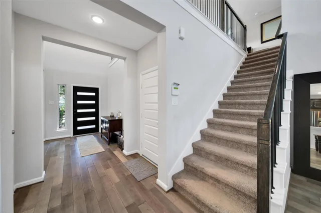a view of an entryway with wooden floor and stairs