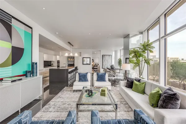 a living room with furniture large window and wooden floor