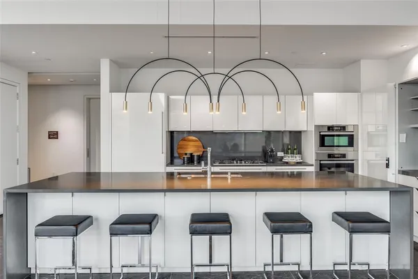 a kitchen with stainless steel appliances granite countertop a table and chairs