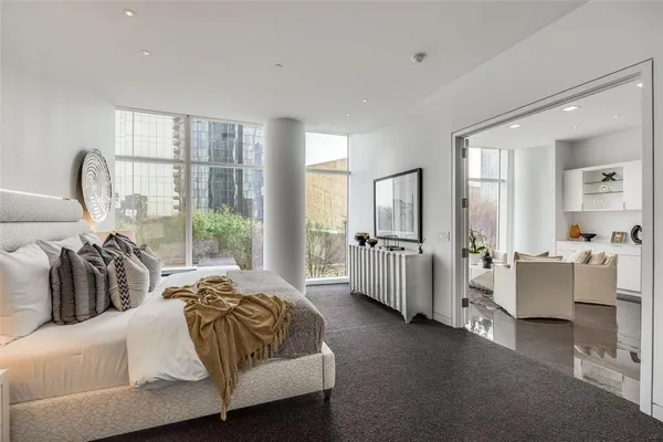 a spacious bedroom with a bed and large windows