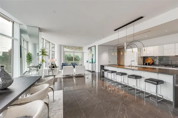 a large living room with stainless steel appliances granite countertop furniture and a large window