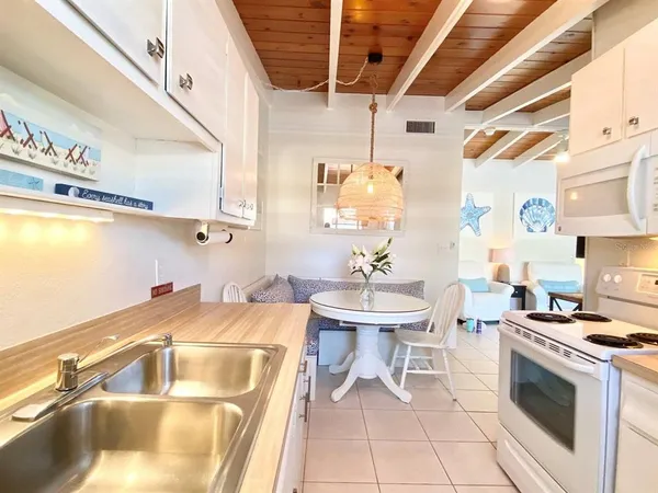 a kitchen with a sink a stove and a microwave oven