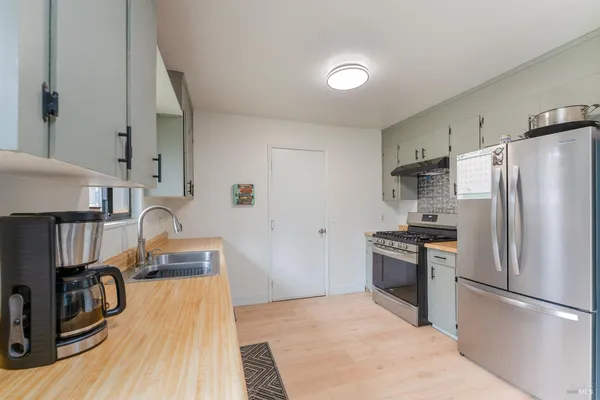 a kitchen with granite countertop a refrigerator stove and sink