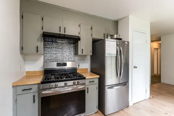 a kitchen with refrigerator a stove and a wooden floors