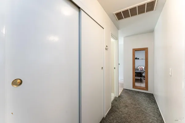 a view of a hallway with wooden cabinets