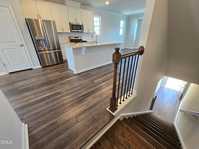 a view of kitchen with sink microwave and refrigerator