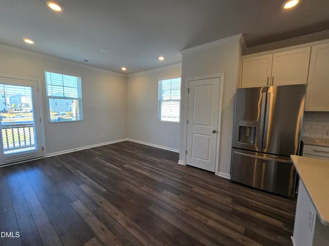 a kitchen with stainless steel appliances wooden floors and large window