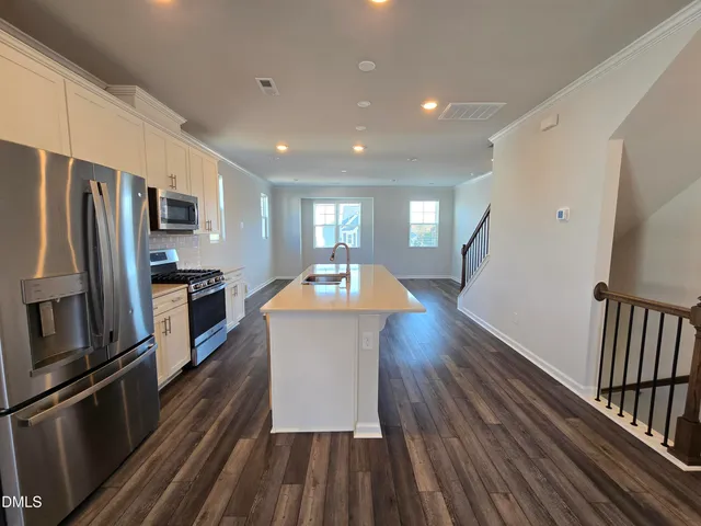 a kitchen with sink a refrigerator and wooden floor