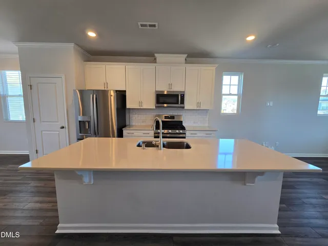 a room with wooden cabinets and stainless steel appliances