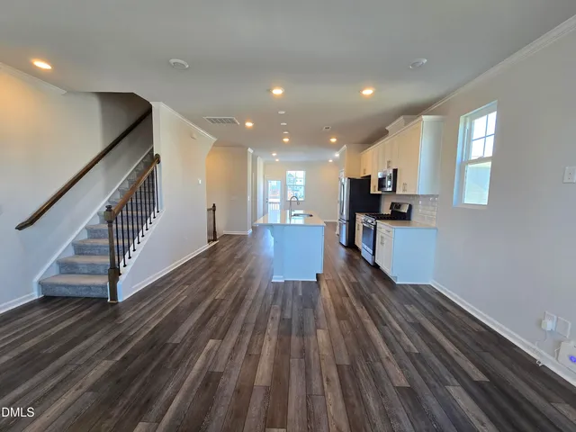 a view of a living room with wooden floor and stairs