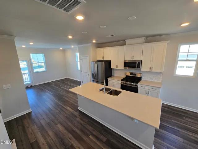 a kitchen with wooden floor and window