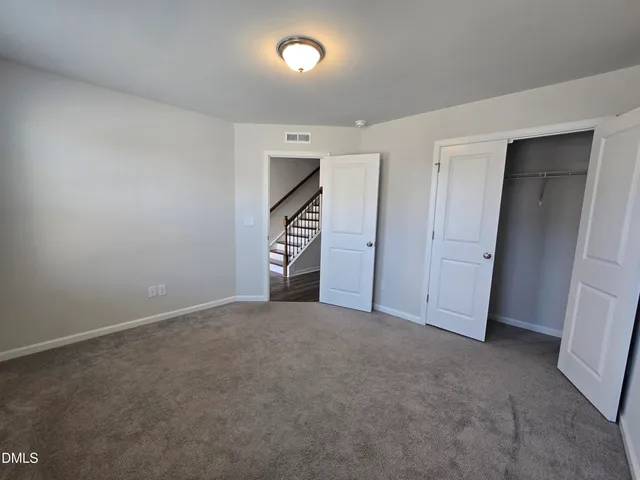 an empty room with closet and windows