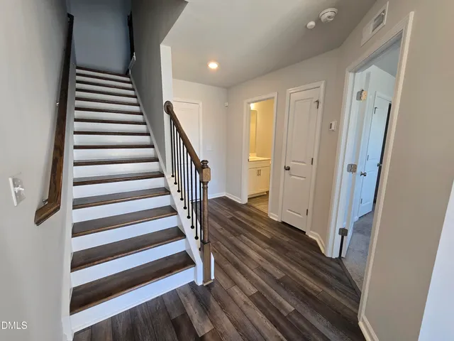 a view of a hallway with wooden floor and entryway