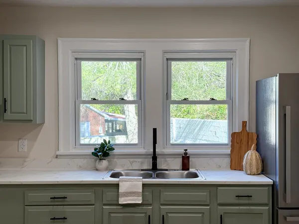 a kitchen with a window sink and cabinets