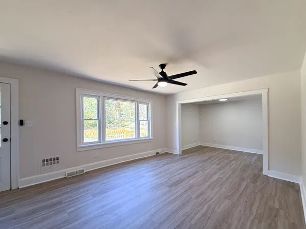 a view of an empty room with wooden floor