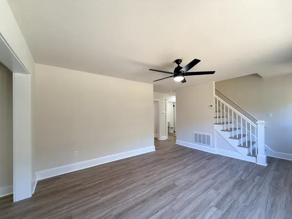 an empty room with wooden floor and windows