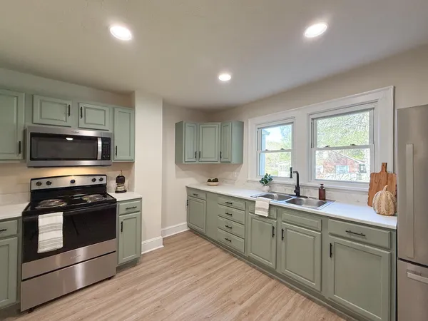 a kitchen with stainless steel appliances granite countertop a stove a sink and a microwave