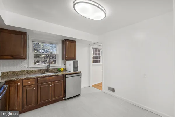 a spacious bathroom with a granite countertop sink and mirror