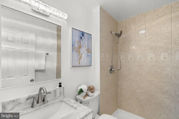 a bathroom with a granite countertop sink toilet and shower
