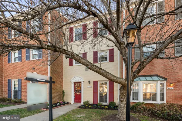 a view of a white house with a large tree
