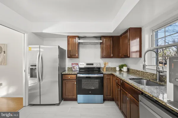 a kitchen with stainless steel appliances granite countertop a sink stove and refrigerator