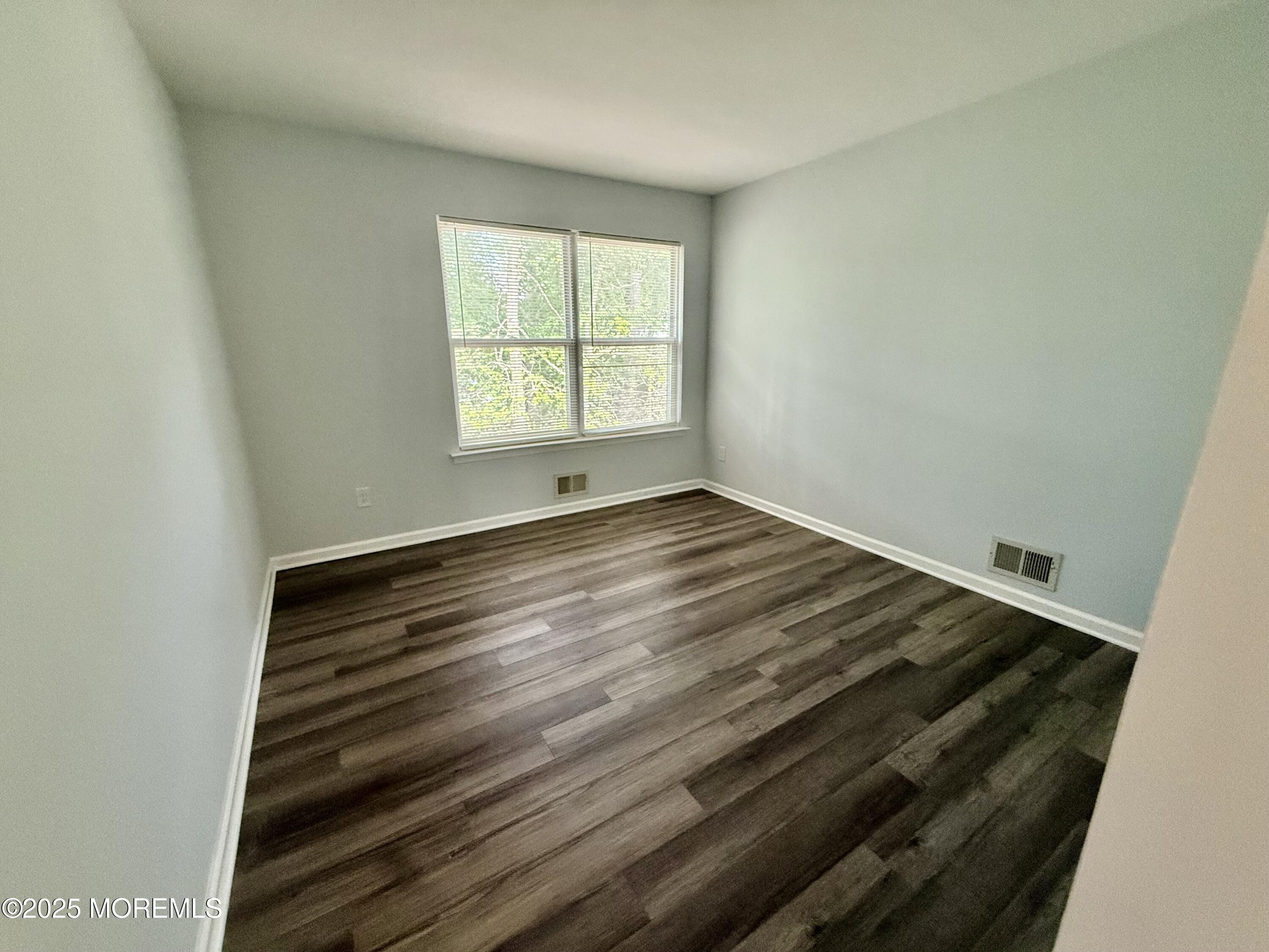 28 Atrium Way Manalapan, NJ 07726 - Photo 11 of 13 an empty room with wooden floor and windows