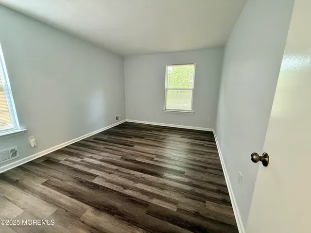 a view of a room with wooden floor and window