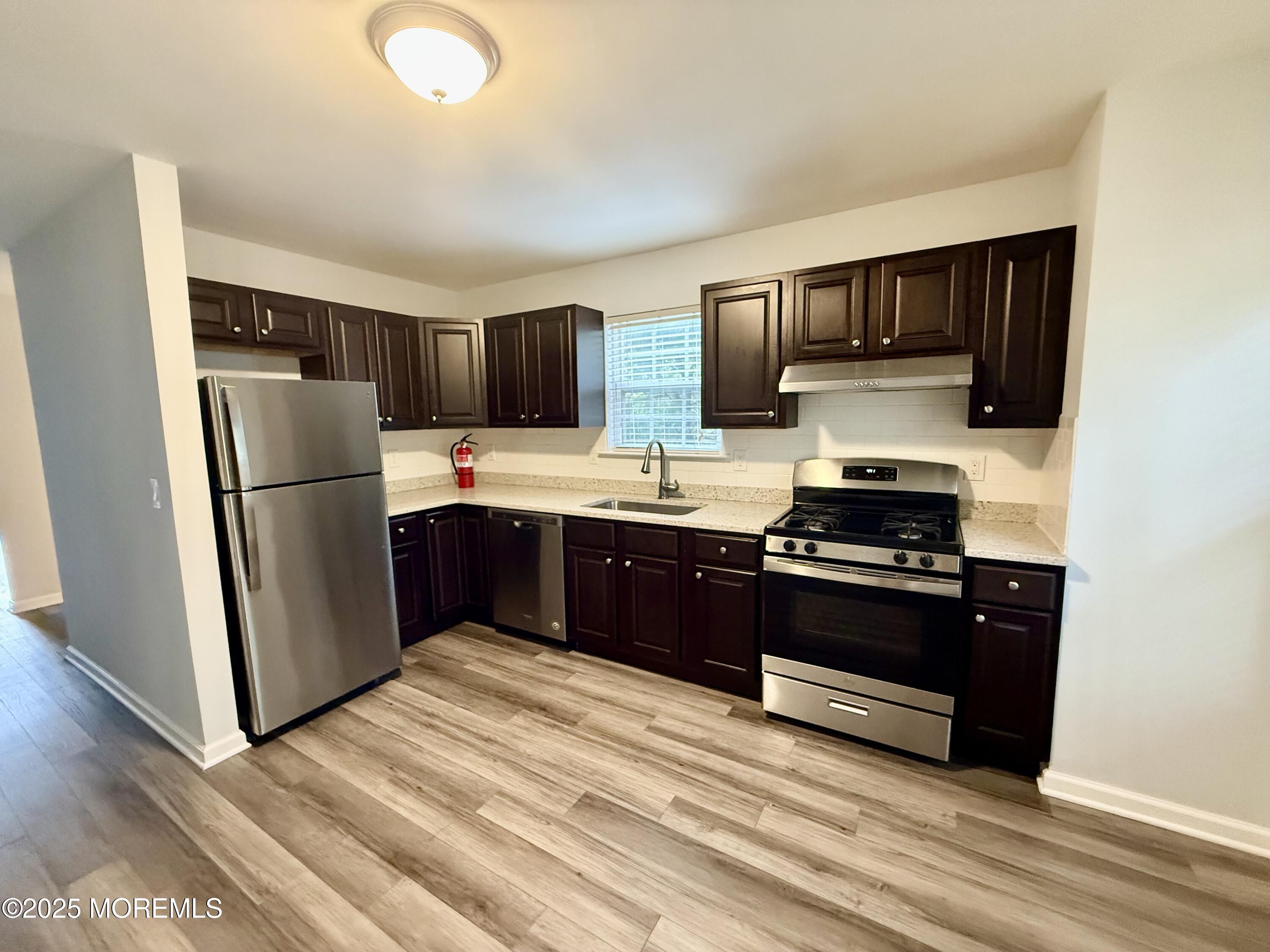 28 Atrium Way Manalapan, NJ 07726 - Photo 2 of 13 a kitchen with stainless steel appliances granite countertop a refrigerator stove a sink and a granite counter tops
