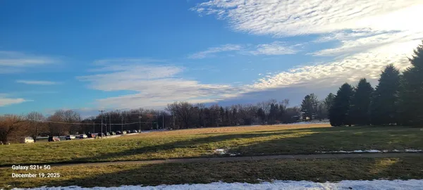 a view of a fountain is middle in the middle of a field